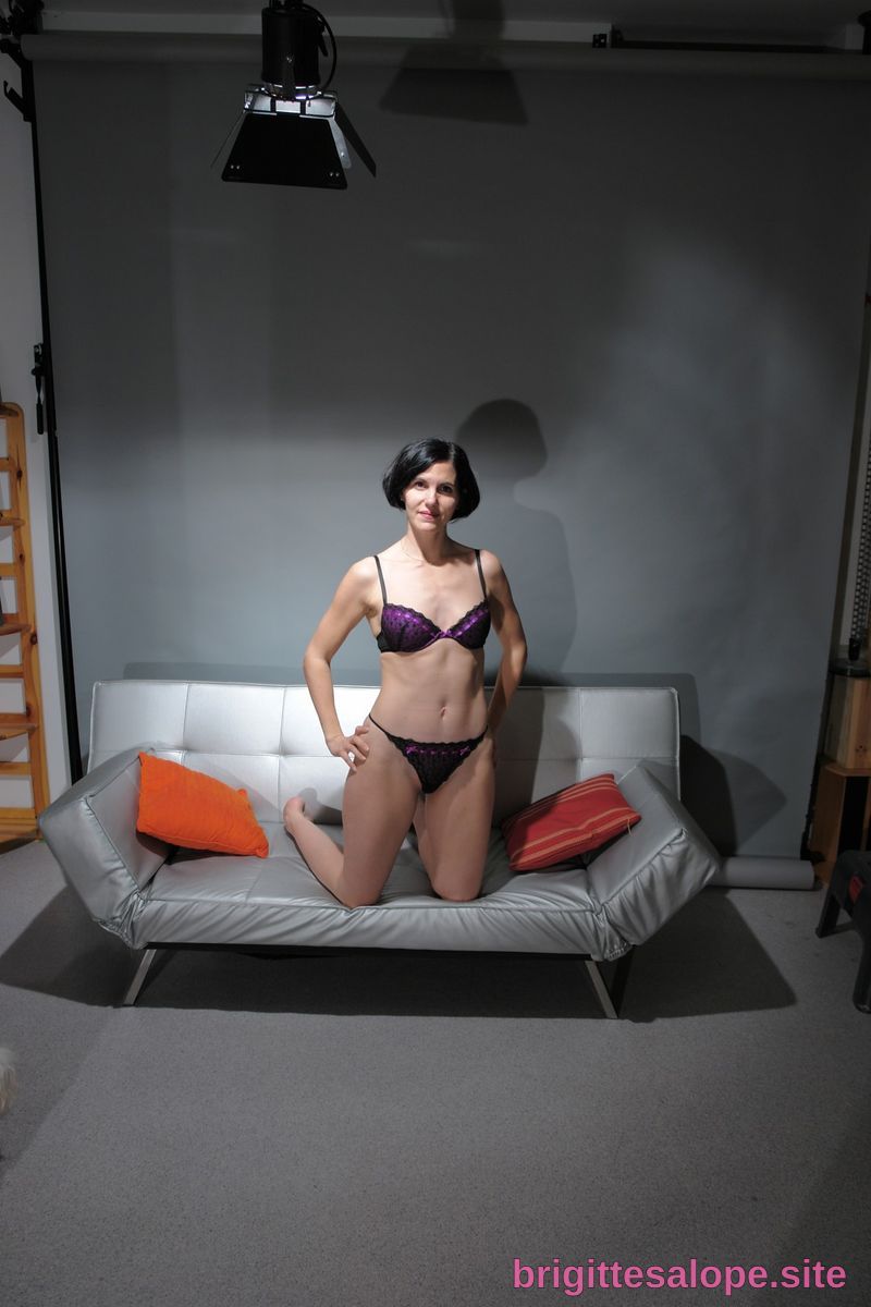 Femme en lingerie noire sur un canapé gris — Brigitte la Salope
