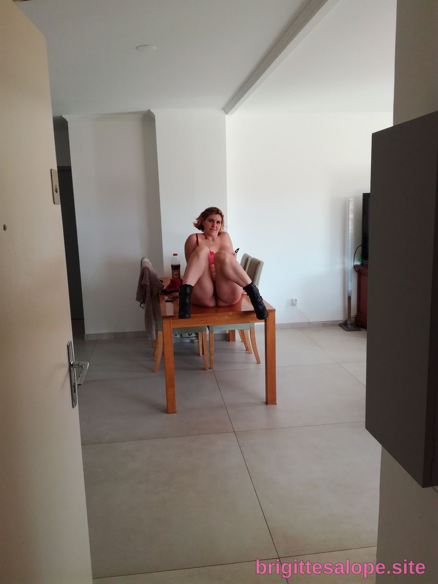 Femme assise sur une table dans un intérieur lumineux — Brigitte la Salope