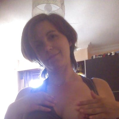 Femme assise, seins exposés, camisole noire, lumière arrière… — Brigitte la Salope