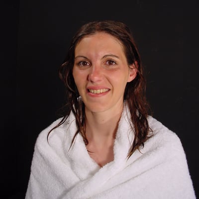 Femme souriante avec un drapé blanc sur un fond noir — Brigitte la Salope