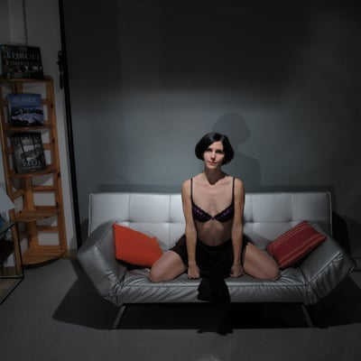 Femme assise sur un canapé noir — Brigitte la Salope