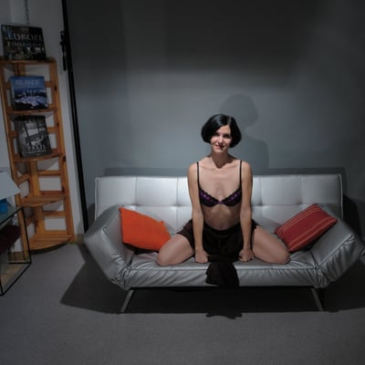 Femme assise sur un canapé noir (photo 1716) — Brigitte la Salope