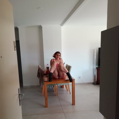 Femme assise sur une table dans un intérieur lumineux — Brigitte la Salope
